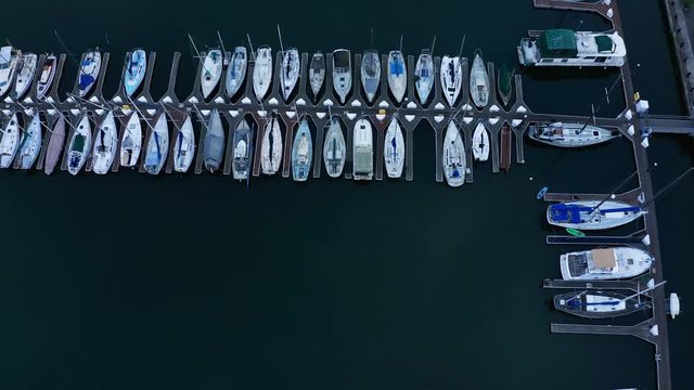 A slow pass over sail boats in the marina day.