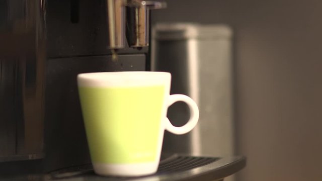 close up of a cup of coffee thats being made by a machine.