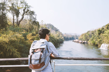 Senior man  with backpack  enjoying view, looking river, relax weekend holiday concept.