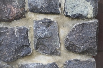 Close-up of part of the wall. Masonry of gray, uneven stones. Background, texture.