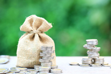 Stack of coins money and a bag on natural green background, Business investment growth and Save money for prepare in future concept,Finance