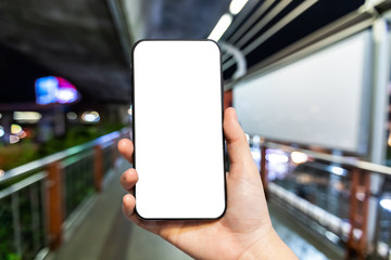 Female use hand holding smartphone with empty white screen blurred images touch of Abstract blur in The walk way walking on the Skywalk at Bangkok,the big city travel lifestyle transportation concept