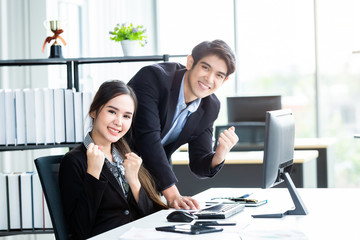 Happy of businesswoman and businessman partners discussing positive adult business working together with computer on wooden table and ideas at meeting in office background.