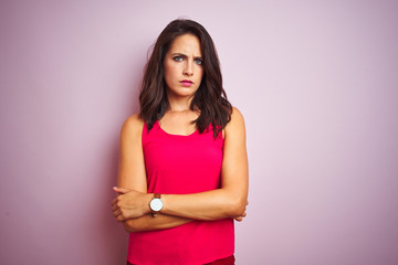 Fototapeta premium Young beautiful woman wearing t-shirt standing over pink isolated background skeptic and nervous, disapproving expression on face with crossed arms. Negative person.