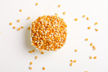 Dried corn seeds in bowl on white background 