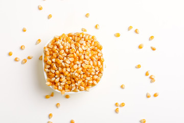 Dried corn seeds in bowl on white background 
