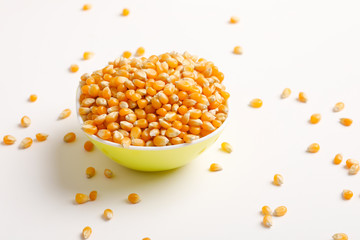 Dried corn seeds in bowl on white background 