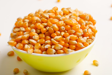 Dried corn seeds in bowl on white background 