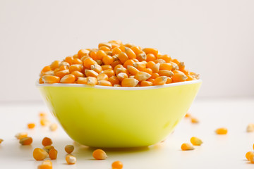 Dried corn seeds in bowl on white background 