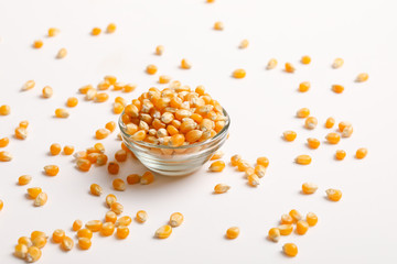 Fototapeta na wymiar Dried corn seeds in bowl on white background 