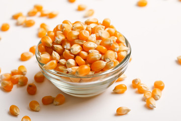 Dried corn seeds in bowl on white background 
