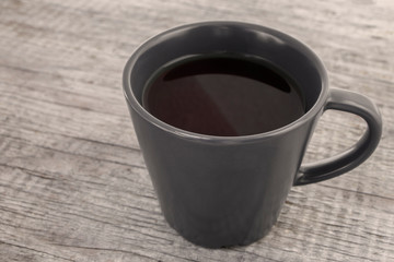 A cup of coffee on grunge wooden table in dark tones. Concept of bored, tired, depressed,  Monday morning mood in work
