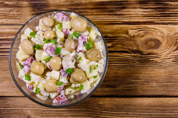 Obraz na płótnie Canvas Salad with marinated mushrooms, sausage, onion, boiled potato and mayonnaise on a wooden table. Top view