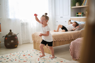 Child glasses with Down syndrome jumping in room