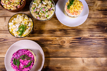 Set of festive mayonnaise salads on wooden table. Top view
