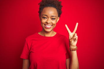 Young beautiful african american woman with afro hair over isolated red background showing and pointing up with fingers number two while smiling confident and happy.