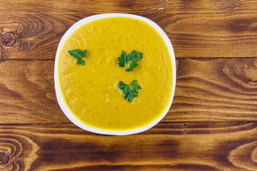 Pumpkin soup on a wooden table. Top view