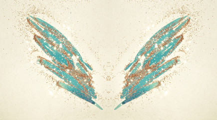 Golden glitter on abstract blue watercolor wings in vintage nostalgic colors.