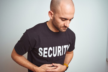 Young safeguard man wearing security uniform over isolated background with hand on stomach because...