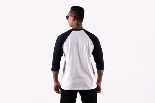 Six Pack man tattooed wearing black white raglan t-shirt 3/4 sleeve in back view isolated on white background