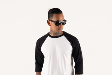 Young man wearing blank plain t shirt isolated on white background. Young hipster man wearing raglan 3/4 sleeve and sunglasses while posing. Ready for your mockup design