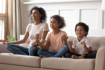 Happy black mom practice yoga with little kids