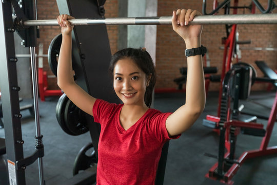 Picture cute of a smile asian woman exercising building muscles in the gym, concept of healthy lifestyle
