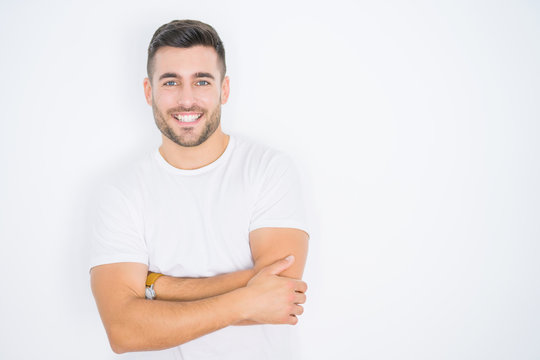 Young handsome man wearing casual white t-shirt over white isolated background happy face smiling with crossed arms looking at the camera. Positive person.