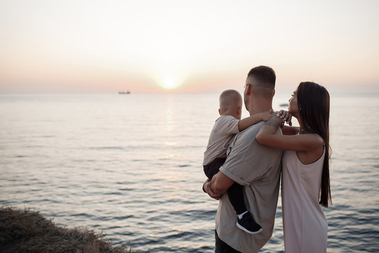 Young family with a child on a walk in the city in summer.Love and trust as family values. Mother and father with son outdoor. Summer vacation of happy family. Child with father and mother. Family wit