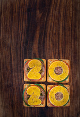 Happy new year 2020 - the year 2020 made from cheese and soda biscuits or crackers with tomato and baby spinach on a wooden board