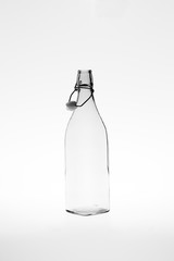 Monochromatic image of a retro empty square glass bottle with an open clip top stopper