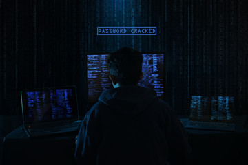 Internet crime concept. Hacker working on a code on dark digital background with digital interface around.