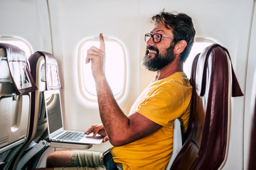 Bearded caucasian adult man sit down inside the airplane flight asking for hostess help -modern...