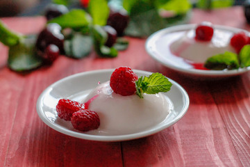 Panacota decorated with raspberries and mint