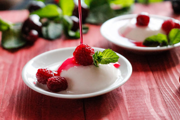 Panacota decorated with raspberries and mint