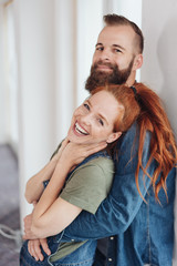 Laughing vivacious woman in her husbands arms