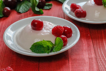 Panacota decorated with raspberries and mint