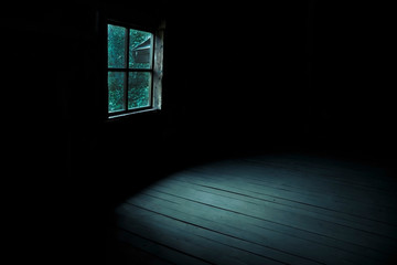 Abstract horror background for halloween. Gloomy scary terrible window with ghostly light and shadows in a dark black room in the attic, corridor or basement in an abandoned house in the forest