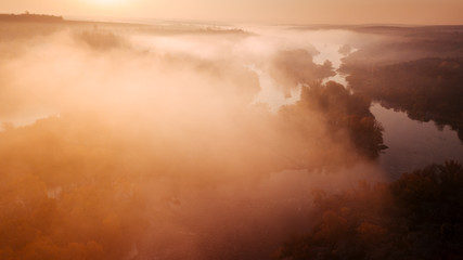 amazing aerial view on sunrise. foggy river and golden  trees. beautiful autumn landscape. drone shot, bird's eye