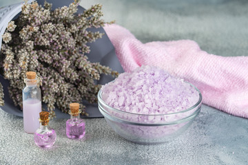 Obraz na płótnie Canvas Lavender spa setting: salt, essential oil and dried flowers natural spa products and decor for bath on light background