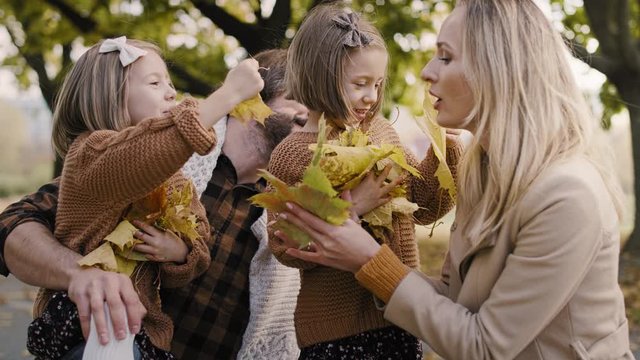 Happy family picking leafs on the fall season
