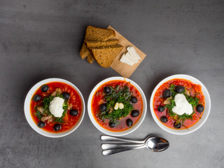 Traditional Ukrainian Russian borscht with olives, dill, garlic, lard on the bowls. Beetroot soup Top view. Traditional Ukraine food cuisine