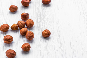 Hazelnuts nuts lie on a white wooden background