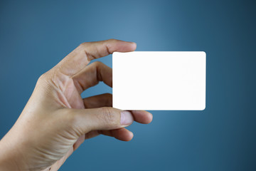 Obraz premium Hand holding a blank piece of paper. Close up white business card.
