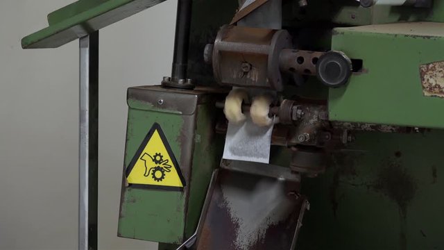 Work of the machine for slicing tea bags. Sao Miguel Island,  Azores, Portugal.