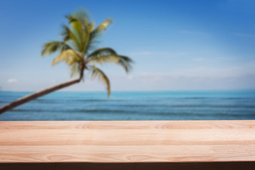 Empty wooden table on the background of tropical beach with palm.