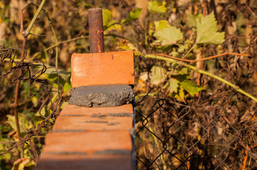 Building a wall with red brick. Working with bricks for building a wall, Construction tools