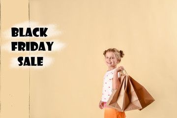 black friday sale.fashionable child in trendy suit jumping with craft package, big purchases not a bright yellow background. black friday banner concept.
