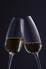 two glasses with champagne on a dark background