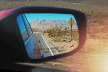 Road reflecting in the sideview mirror of a car
